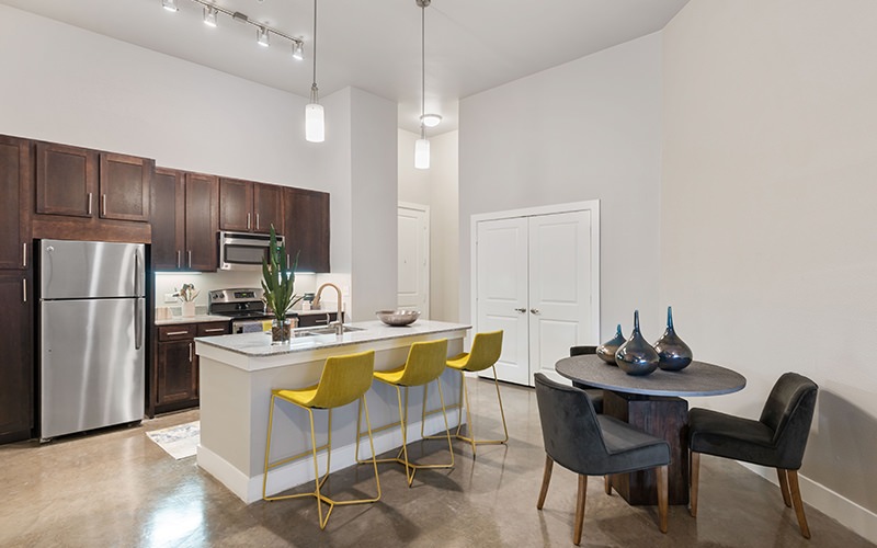 Spacious and well lit kitchen with wood floors and granite counters 
