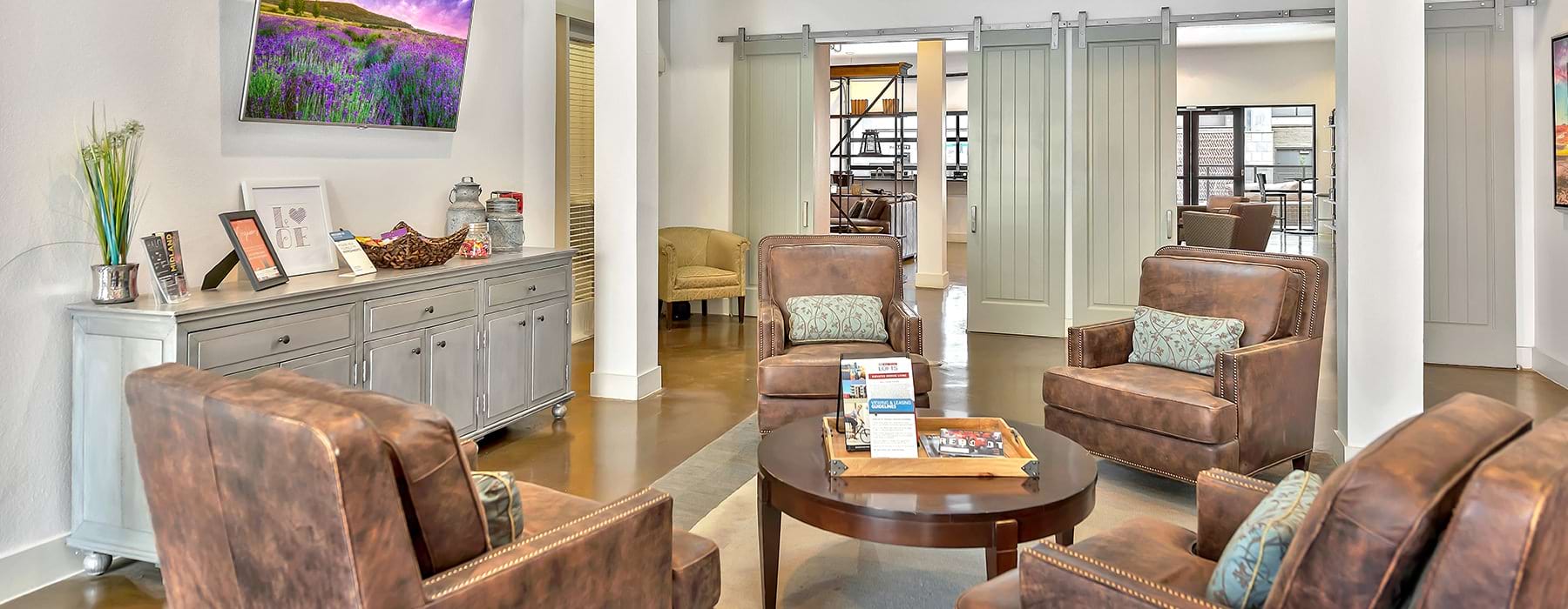 Spacious and well lit living room with wood floors and access to the kitchen 