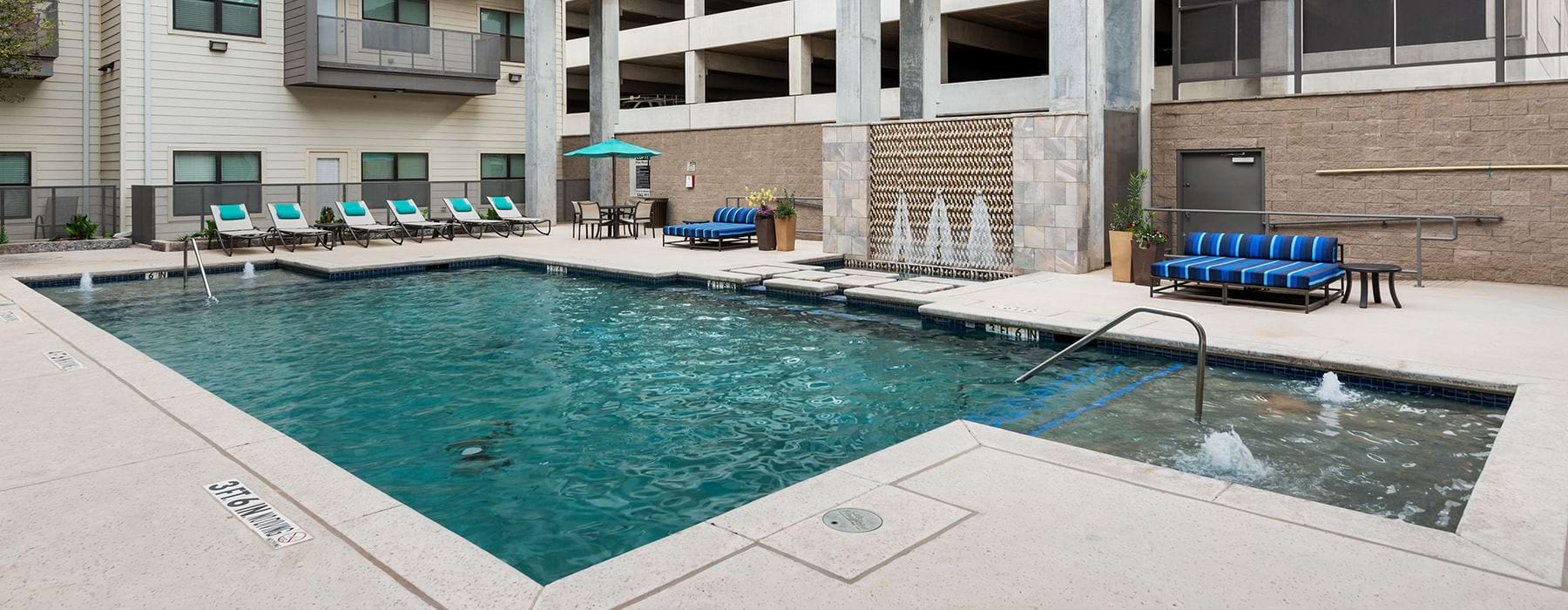 Sparkling swimming pool with large pool deck and cabanas