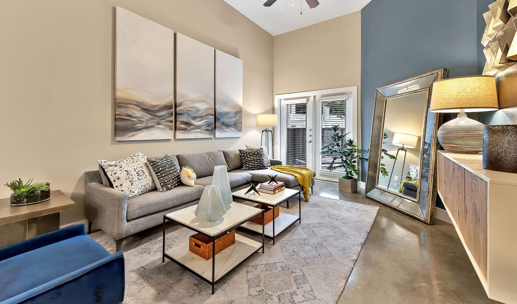 Spacious and well lit living room with wood floors and a large window